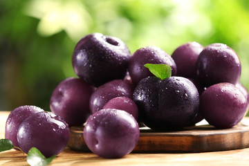 Ripe juicy plums on table