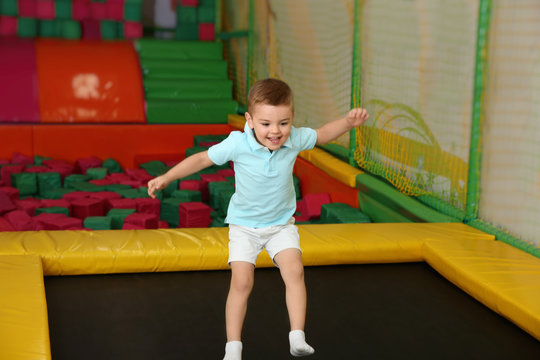 Cute boy jumping on trampoline in entertainment center