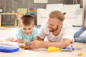 Obraz premium Father playing with cute son at home
