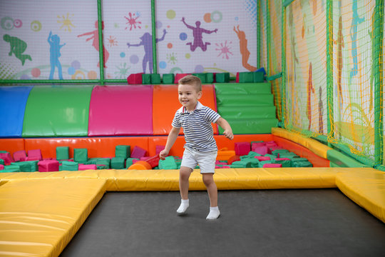 Cute boy jumping on trampoline in entertainment center