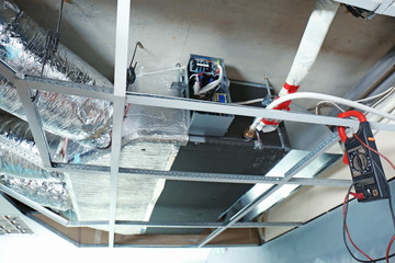Industrial air conditioner and multimeter hanging on ceiling beam indoors