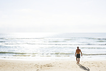 Fototapeta na wymiar Man walking down the beach