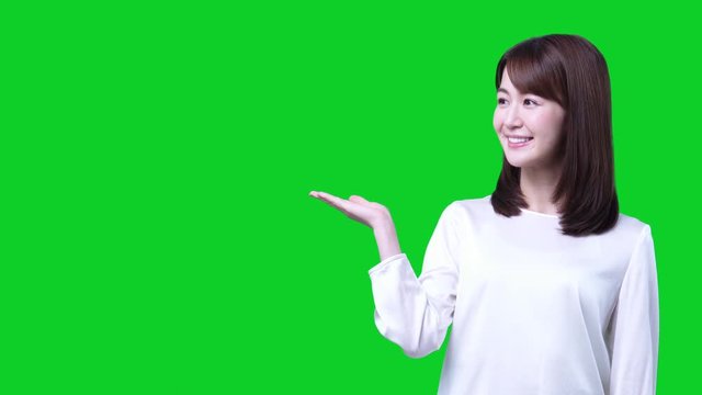 Guiding Young Asian Woman. Green Background For Chroma Keying.