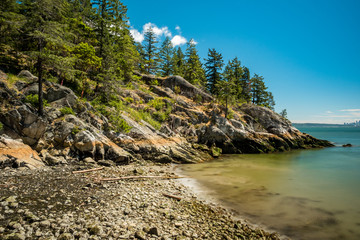 Fototapeta na wymiar rocky beach on the edge of the island under the blue sunny sky