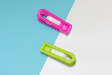 Clothes pins on light blue background, minimal concept idea, flat lay