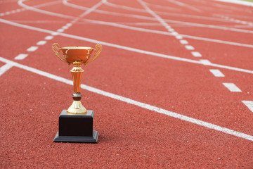 A golden trophy on running track / Competition for success concept