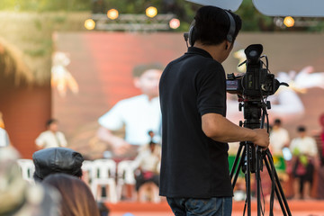 Rear side of Video Cameraman taking photograp to the stage, event and seminar production equipment...