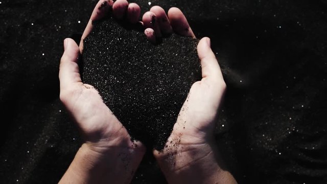 Beautiful black sand in female hands