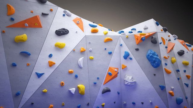 Indoor bouldering wall with colorful climbing holds. Gym indoor extreme training