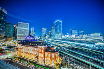 Asia Business concept for real estate and corporate construction - panoramic urban city skyline aerial view and tokyo station with train railroad under twilight sky and neon night in tokyo, Japan