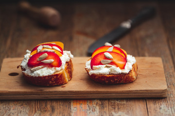 Summer fresh  fruit toast sandwich with soft white cheese on a vintage rustic table top wood background