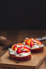 Summer fresh  fruit toast sandwich with soft white cheese on a vintage rustic table top wood background