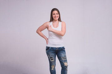 portrait of a beautiful brunette girl on a white background in different poses with a shows on a product.