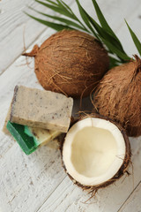 Fototapeta na wymiar Coconut natural organic handmade soap. soap with coconut extract.soap with coconut oil and fresh coconut in a cut on a shabby wooden background. Organic Cosmetics
