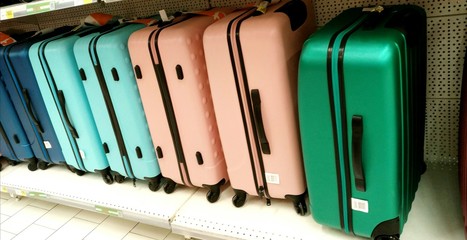 Suitcases. Multicolored suitcases stand in a row along the wall. Bags for carrying things, luggage....