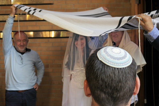 Rabbi belssing Jewish bride and a bridegroom under a chupa