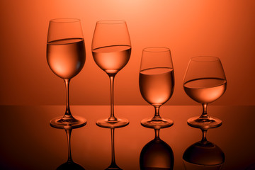 Glasses with water on a red background.