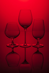 Three glasses on a red background.