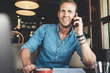 Portrait of entrepreneur working on his project at street cafe, talking on the phone