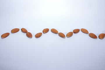 wavy line of nuts (almond) on white background