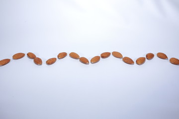 wavy line of nuts (almond) on white background