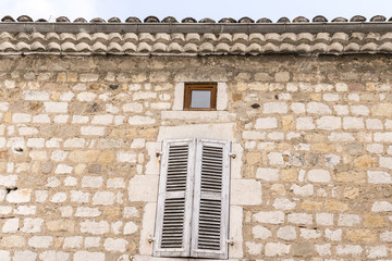 alte hausfassade aus Stein mit einem großen und einem ganz kleinen Fester