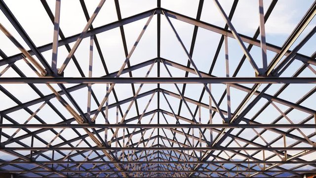 Loopable steel roof truss on a cloudy sky background. Construction building