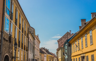Fototapeta na wymiar colorful cozy and small old city street in summer bright day with blue sky background