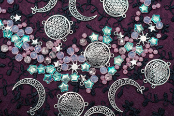 Silver moon and stars pendants and pink opal bead embroidery on fabric