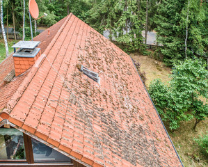 Flight over the red roof of a single family house with a chimney and a satellite antenna for...