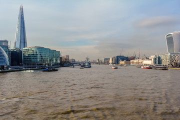 View on London and Thames from Tower Bridge, with Shard, 20 Fenchurch Street and several boats in the water.