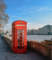 Classic British red telephone box at Thames embankment in London center.