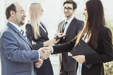 welcome handshake between lawyer and client on the background of business team