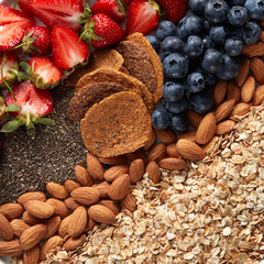 Mix of berries, nuts, oatmeal and granola close-up. Ingredients for dietary nutrition