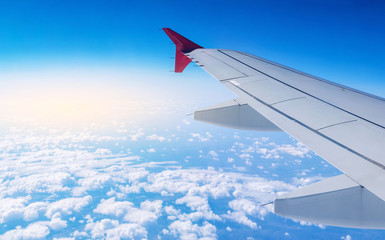Fototapeta premium Wing of airplane in flight on a background of clouds. Concept of travel and flights to new countries