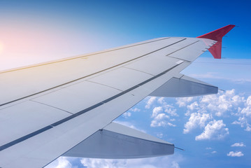 Obraz premium Wing of airplane in flight on a background of clouds. Concept of travel and flights to new countries
