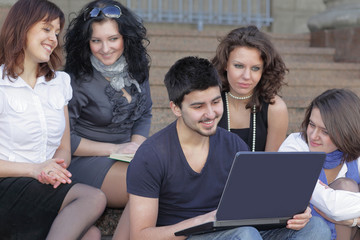 group of students communicating via the Internet using laptop