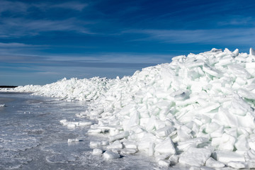 Fototapeta na wymiar frozen lake covered with stack of ice floes and blue sky