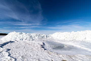 Fototapeta na wymiar frozen lake covered with stack of ice floes and blue sky