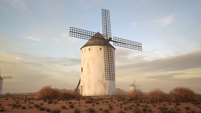 Closeup shot of a vintage Spanish windmill's wings rotating slowly at sunset. 4K