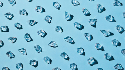 artificial transparent pieces of ice on a blue background with deep shadows