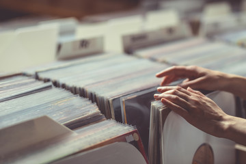 Obraz premium Women's hands browsing vinyl records