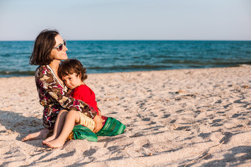 Child with mom on the beach.