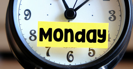 MONDAY. Closeup of word monday sticky note on alarm clock.