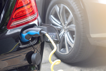 Power supply for hybrid electric car charging battery.Close up of power supply plugged into an...