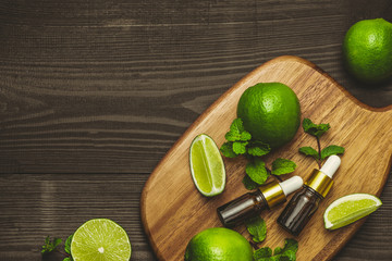 Aromatherapy essential oil bottle with lime fruit and leaf mint.