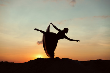 Silhouette of a dancing woman in the desert.