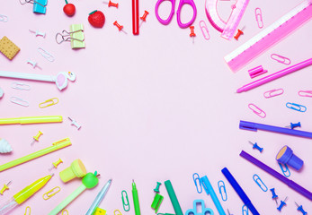 pink background with various School accessories are laid out in the form of a rainbow