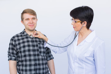 Doctor listening to patients chest with stethoscope over white background