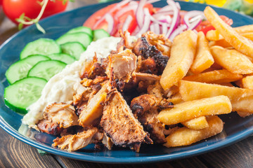 Greek gyros dish with french fries and vegetables